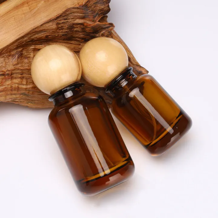 Bernsteinfarbene Glasflaschen mit kugelförmigen Holzverschlüssen