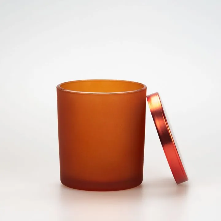 Frosted amber cylindrical candle jar with metal lid beside it
