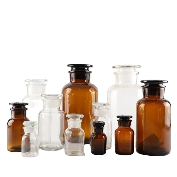 Collection of clear and amber laboratory storage bottles with glass stoppers