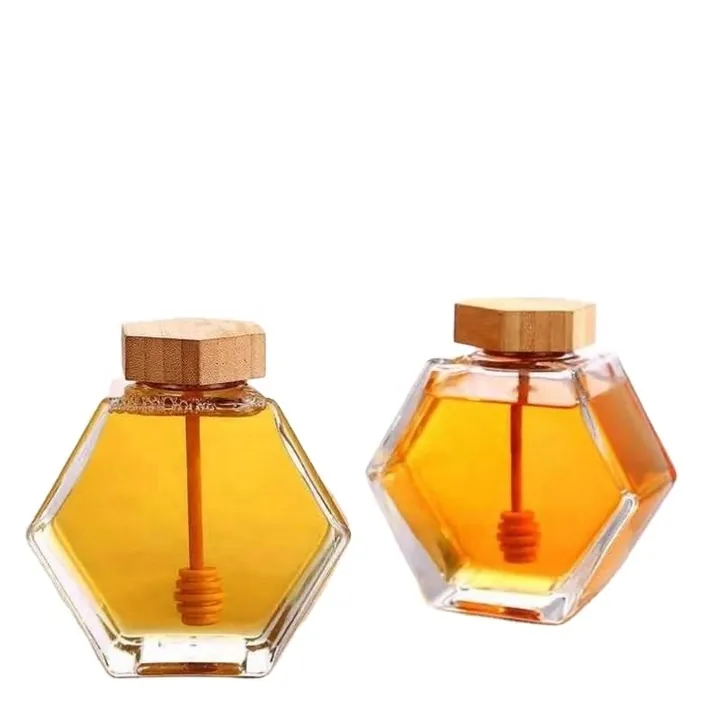 Two hexagon honey jars with bamboo lids and built-in honey dippers