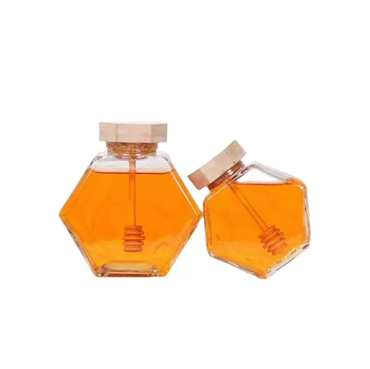 Two hexagon honey jars with bamboo lids and built-in honey dippers