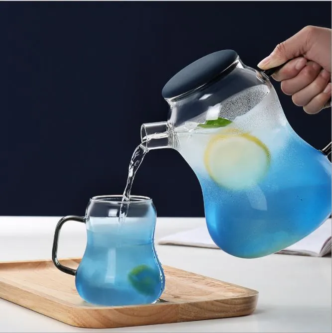 Une carafe en verre bleu versant de l'eau dans un verre assorti