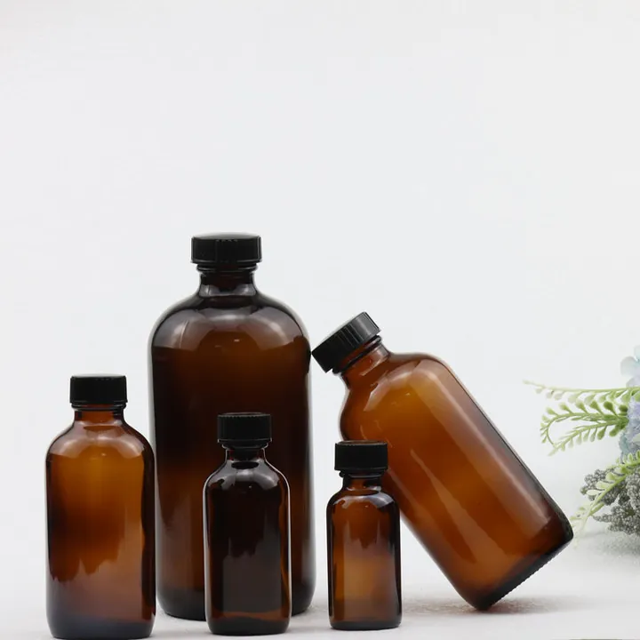 Five amber Boston round bottles displayed with black screw caps