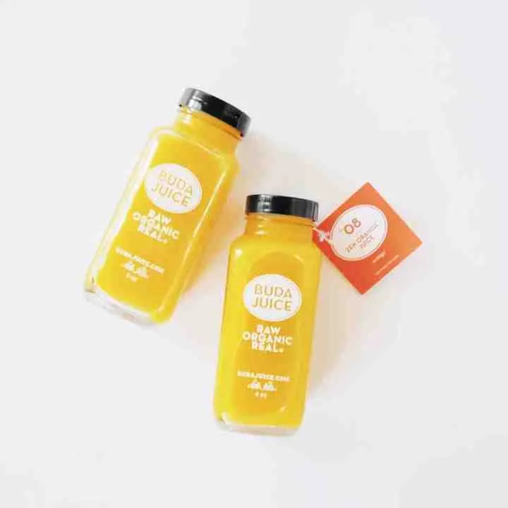 Printed glass shot bottles filled with yellow beverage