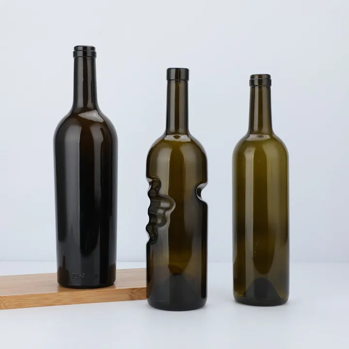 Three dark Burgundy wine bottles including one grip shape bottle