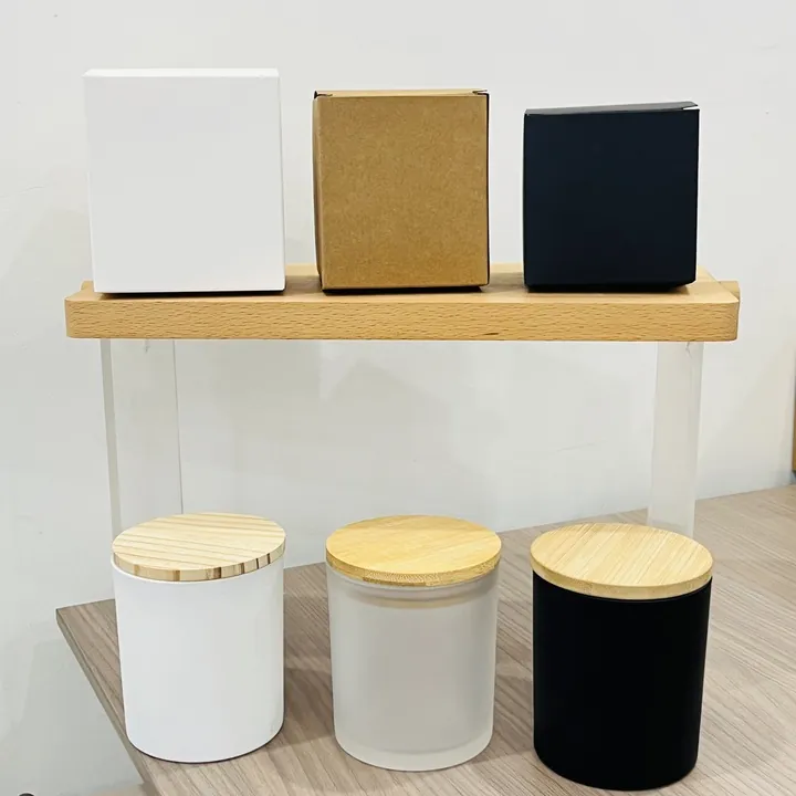 White frosted and black glass candle jars displayed with color box packaging