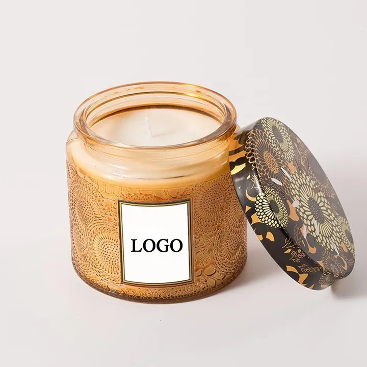 Pot à bougie en verre ambré gaufré, avec couvercle métallique à motifs et étiquette portant le logo