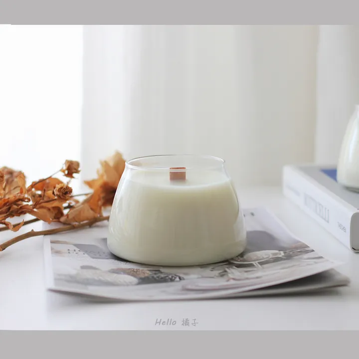 Clear low round glass candle jar filled with white wax