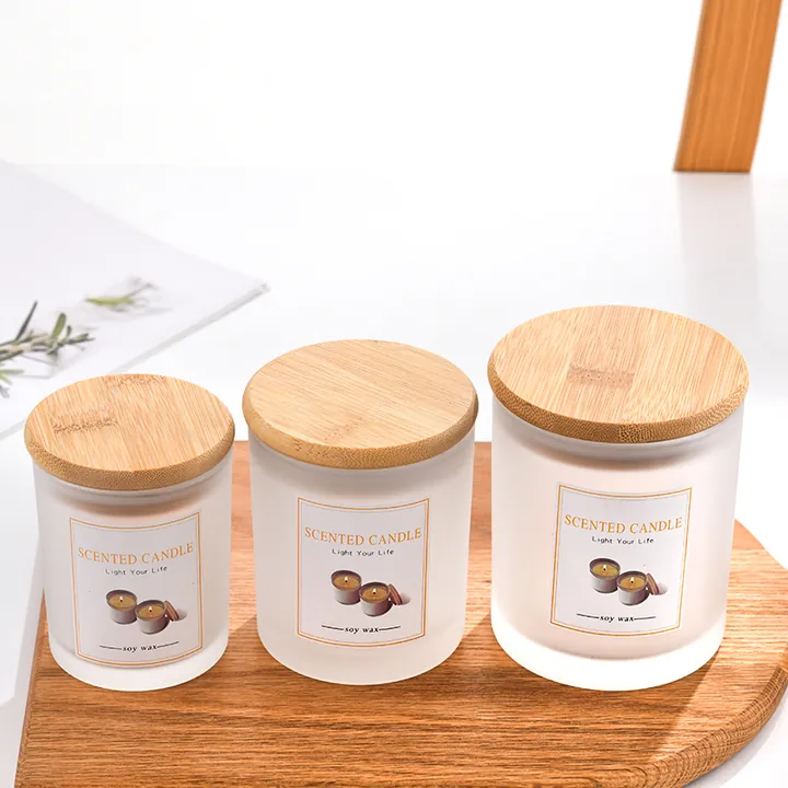 Frosted white candle jars with labels and bamboo wood lids