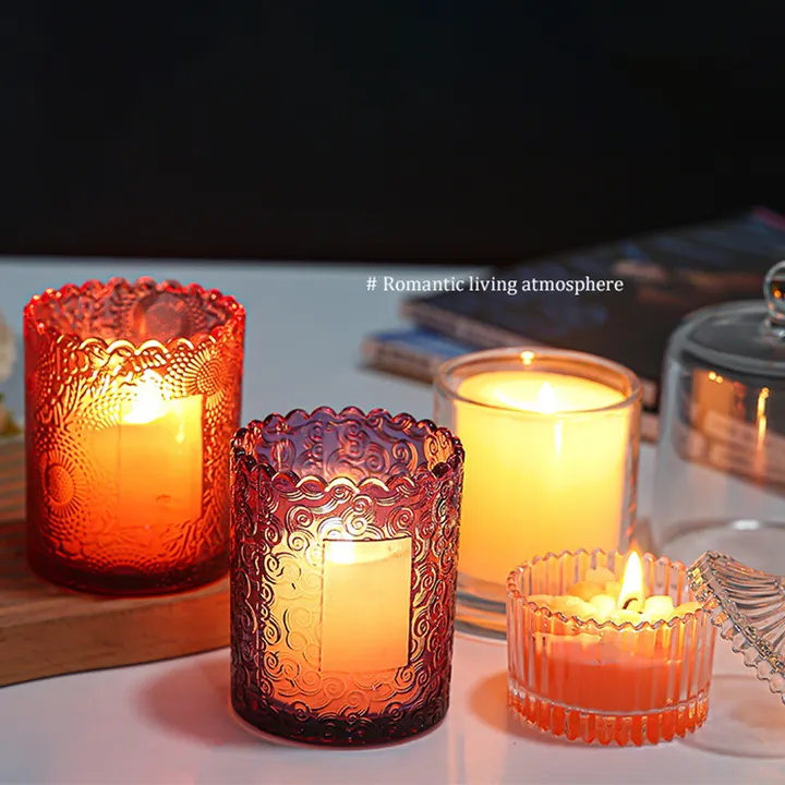 Multiple lit glass candle jars in a warm tabletop scene