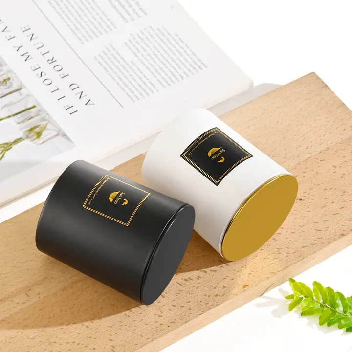 Bocaux à bougies noirs et blancs, avec des couvercles en métal doré et des étiquettes carrées