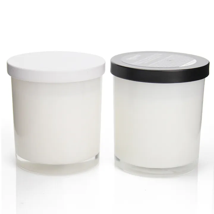 Zwei weiße Kerzengläser aus Glas mit weißen und schwarzen Deckeln