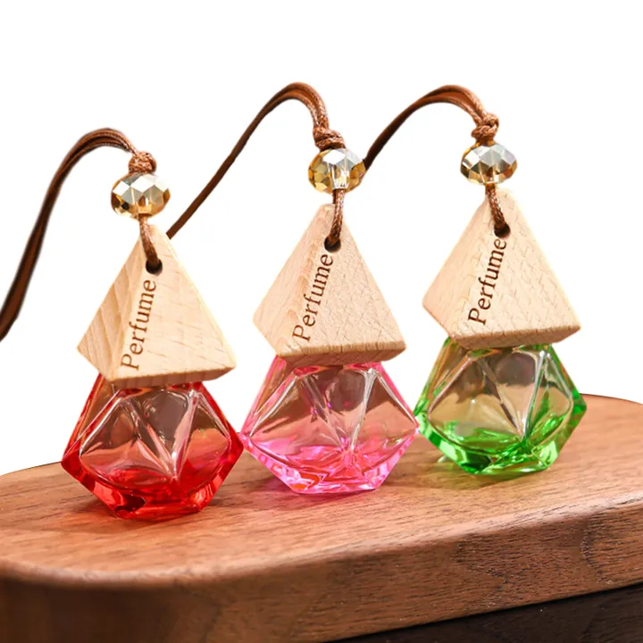 Three colorful diamond shape car diffuser bottles with printed wooden caps and hanging cords