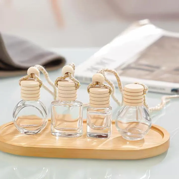 Clear car diffuser bottles with round and square bodies on wooden tray