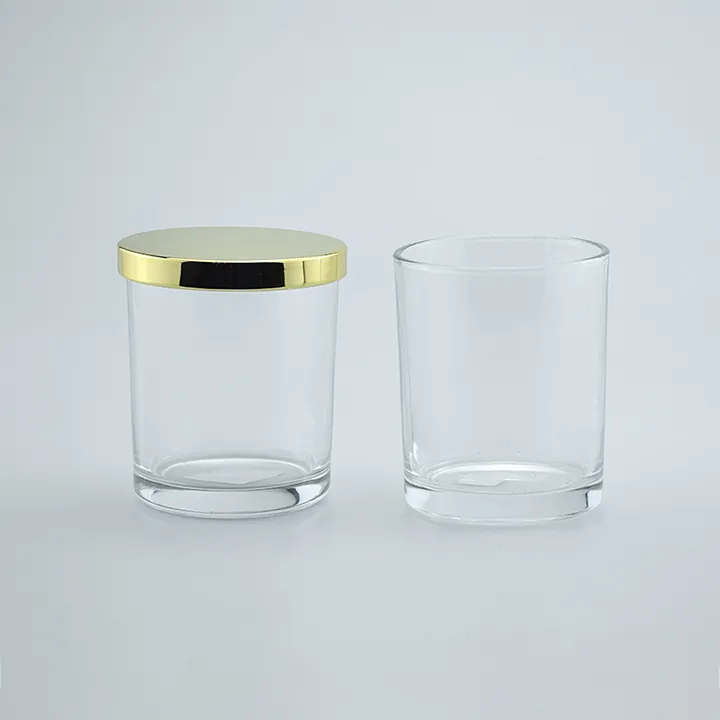 Two clear glass candle jars with one gold metal lid