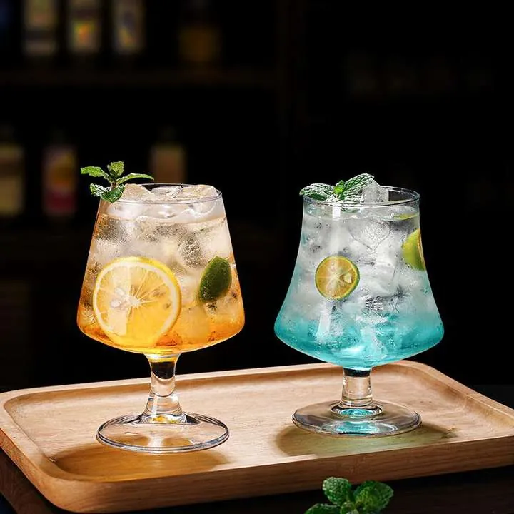 Two cocktail glasses displayed in a bar setting