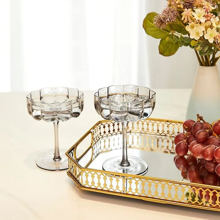Two flower-shaped stemmed cocktail glasses on a tabletop