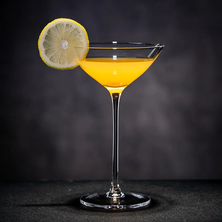 Single martini glass filled with a yellow cocktail