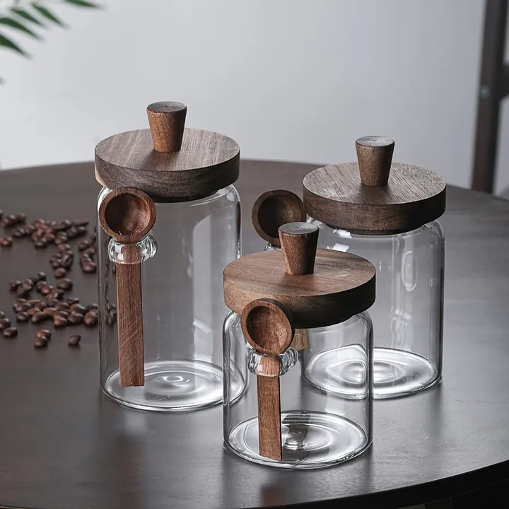 Glass coffee storage jars with wooden lids and spoons
