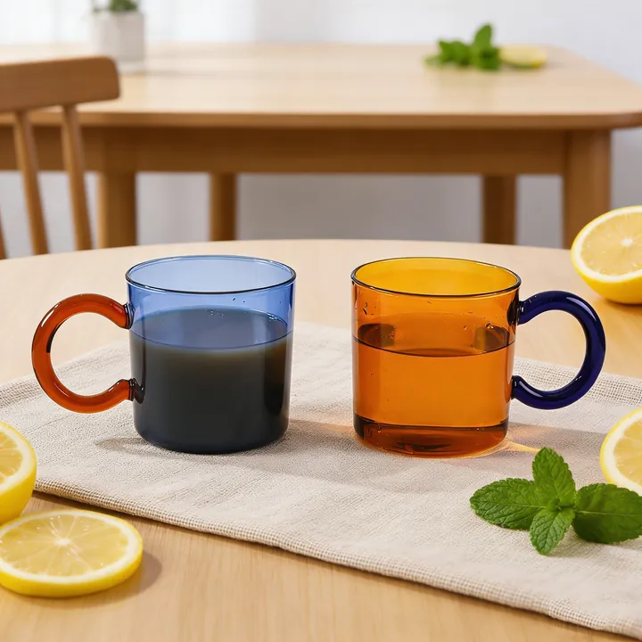 Des verres en verre bleu et ambre avec des anses bicolores sur une table à manger