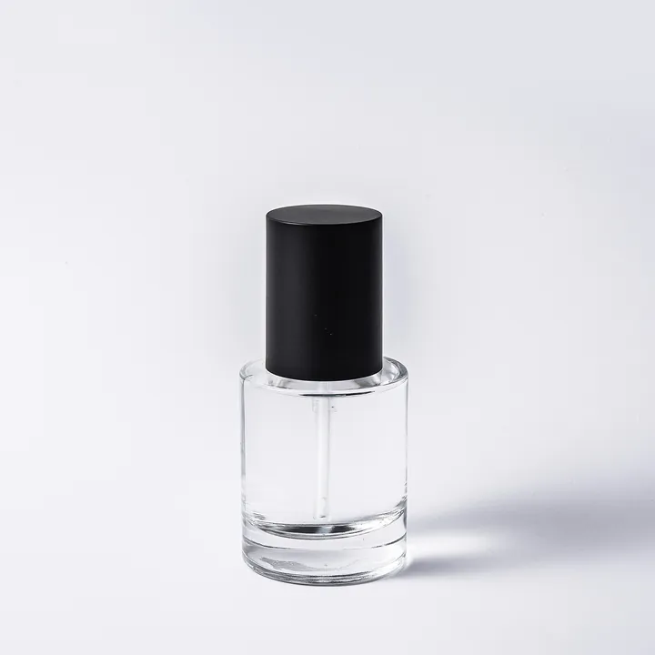 Clear glass cosmetic bottle with black cylindrical cap