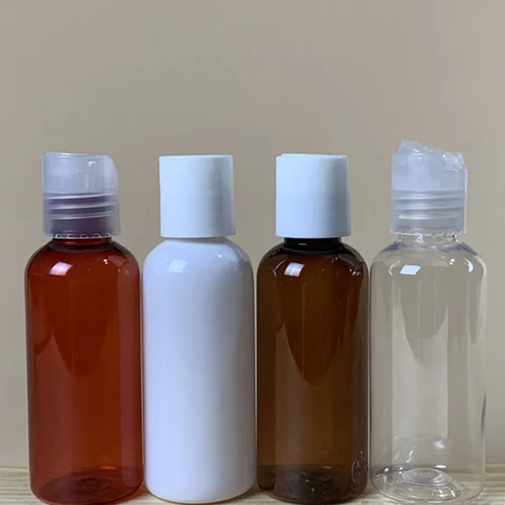 Small clear and brown cosmetic bottles with flip caps and cylindrical caps