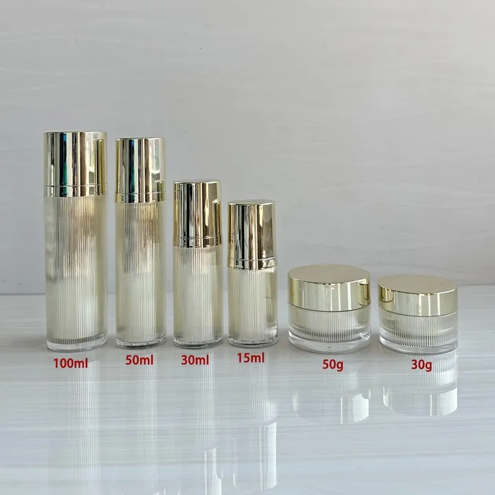 Gold cap cosmetic bottles and cream jars in different capacities displayed together