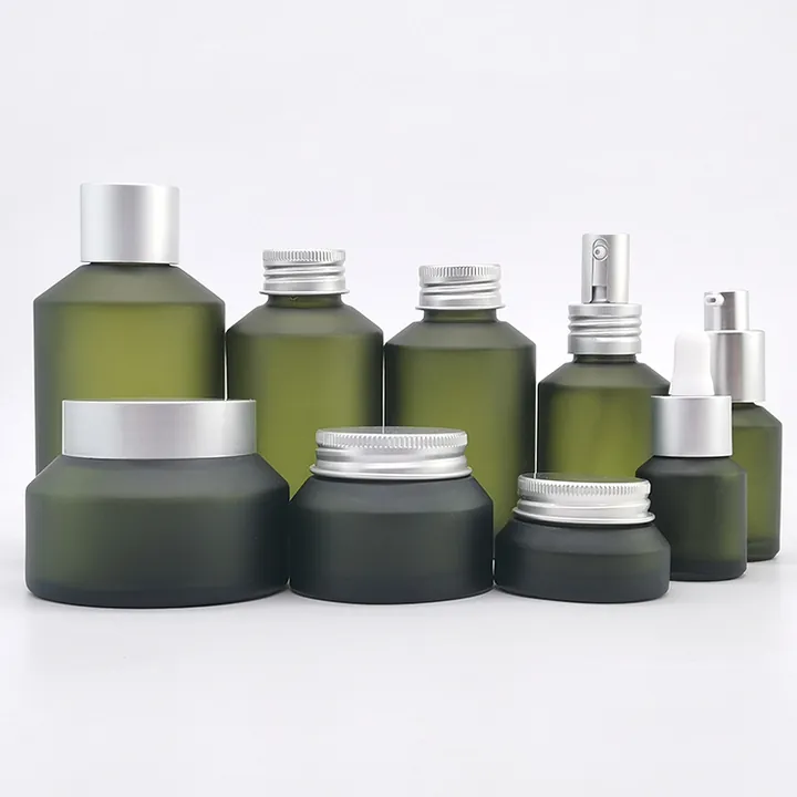 Green frosted cosmetic bottles spray bottle and cream jar displayed together