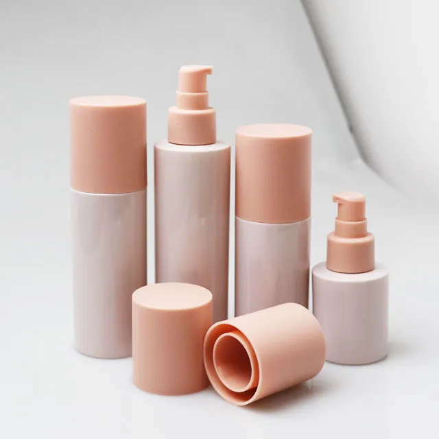 Pink lotion pump bottles and cylindrical cosmetic bottles in different heights