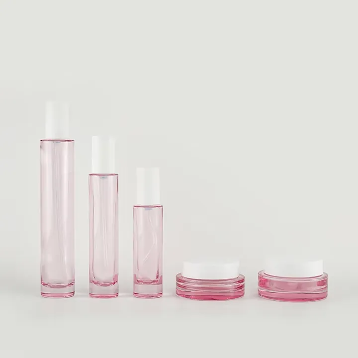 Pink cosmetic glass bottles and jars in a skincare packaging set
