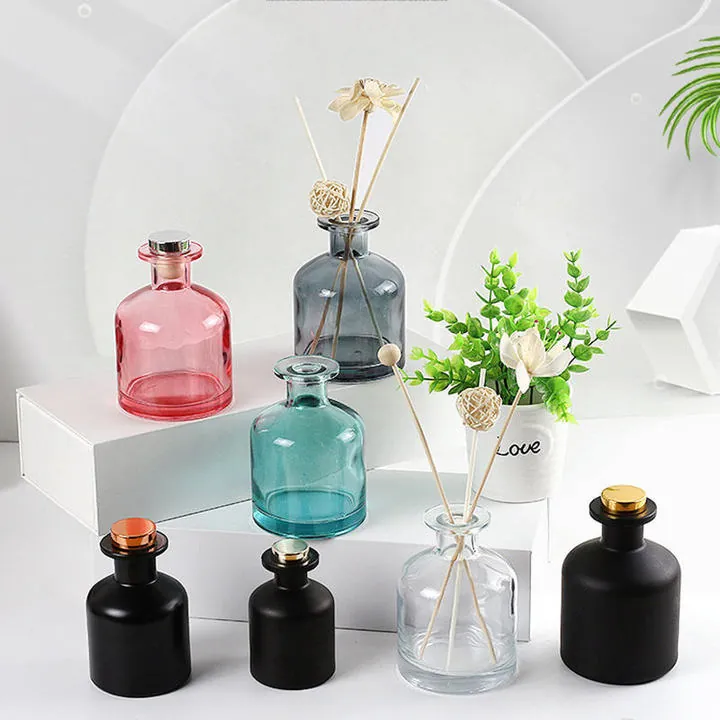 Round diffuser bottles in different colors and surface finishes with reeds and decorative flowers