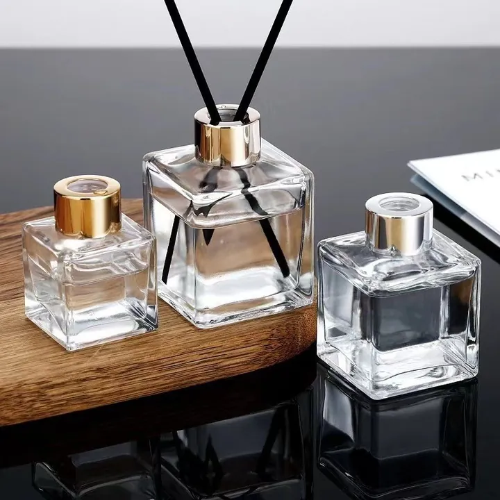 Clear square diffuser bottles with gold openings and black reeds