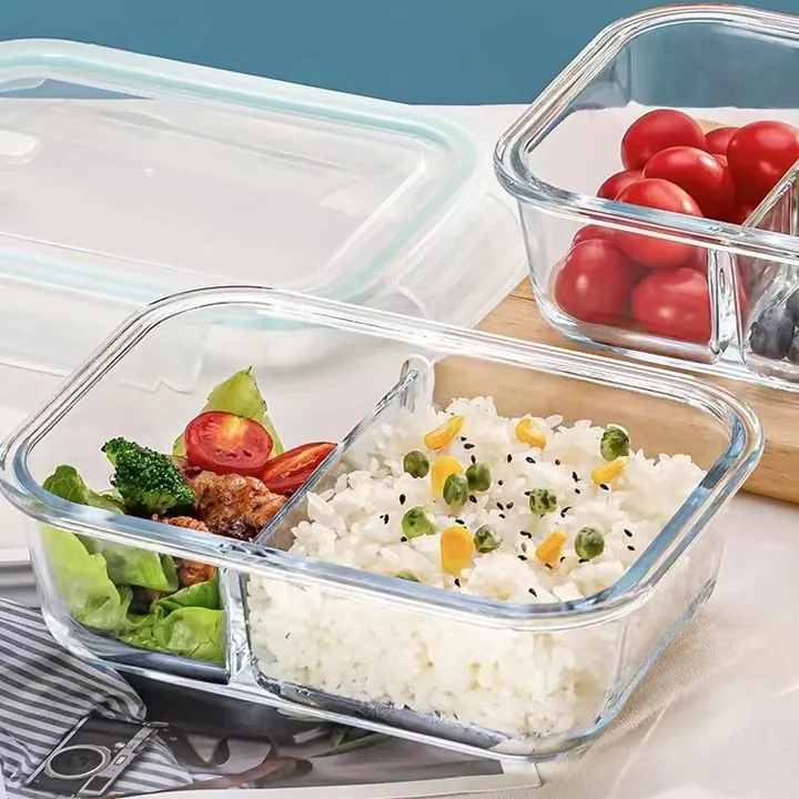 Two compartment glass lunch box filled with rice vegetables and tomatoes