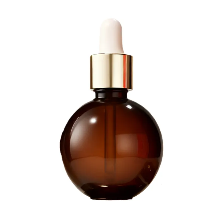 Round amber glass serum bottle with gold dropper cap