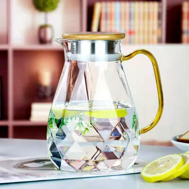 Wasserkaraffe aus facettiertem Glas mit goldenem Henkel und Holzdeckel