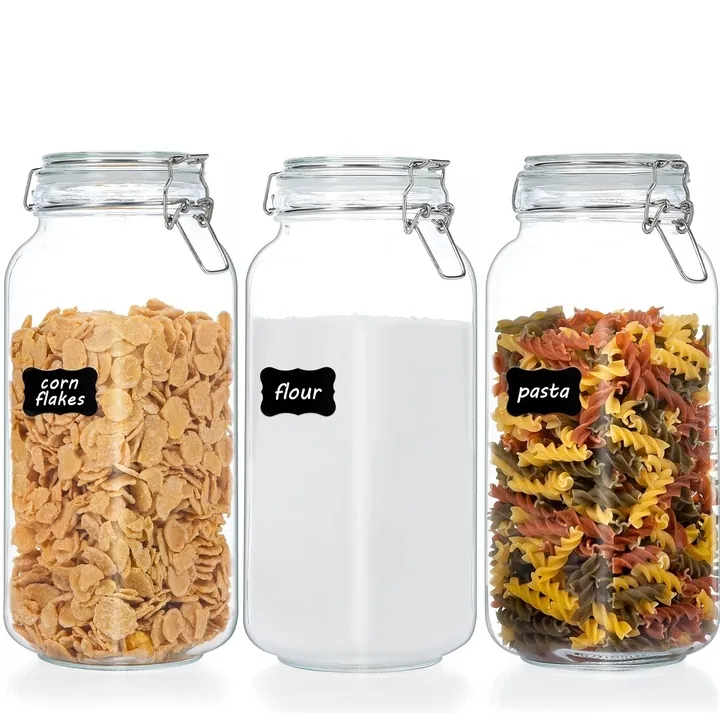 Three clear glass food storage jars with metal clamp lids