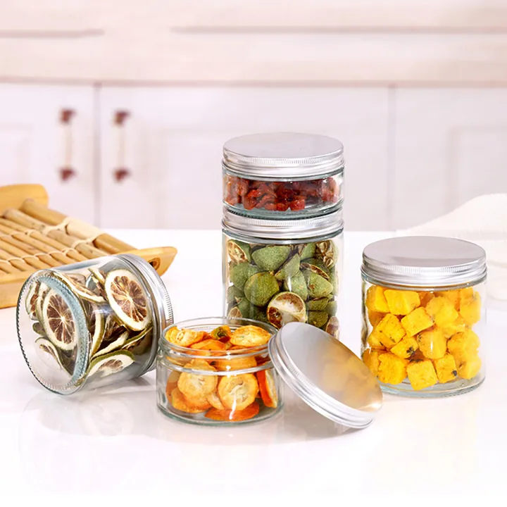 Round clear glass food jars with silver metal lids and preserved foods