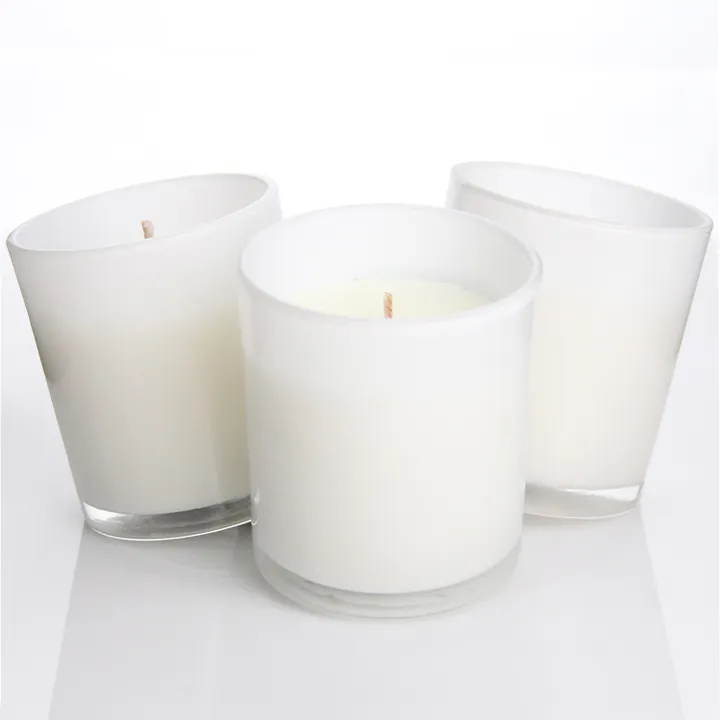 Three frosted glass candle jars filled with white candles