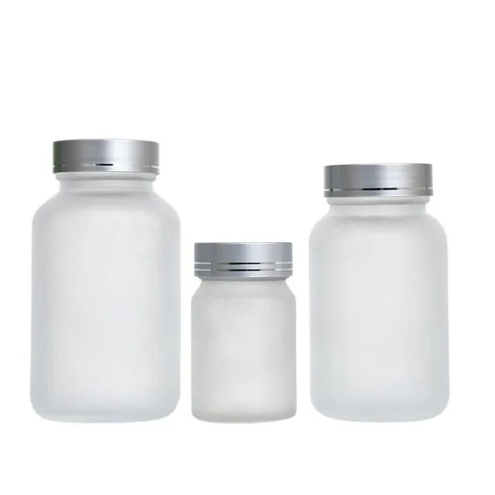 Frosted glass pill bottles in different sizes with silver caps
