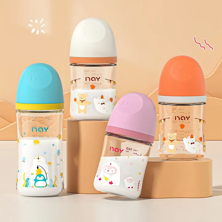 Multiple glass baby bottles with cartoon patterns and colorful caps