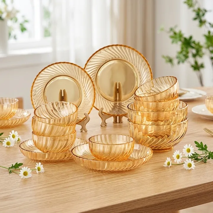 Des bols et des assiettes en verre strié de couleur ambrée disposés sur une table à manger