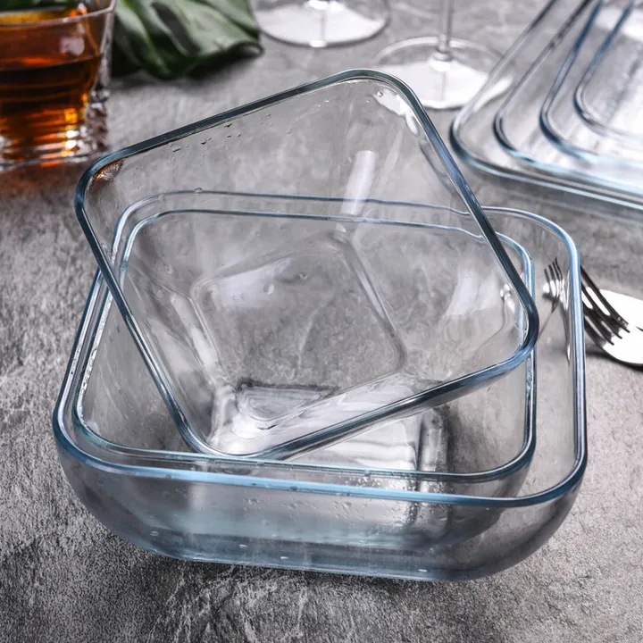 Trois bols de cuisson carrés en verre transparent posés sur une table à manger
