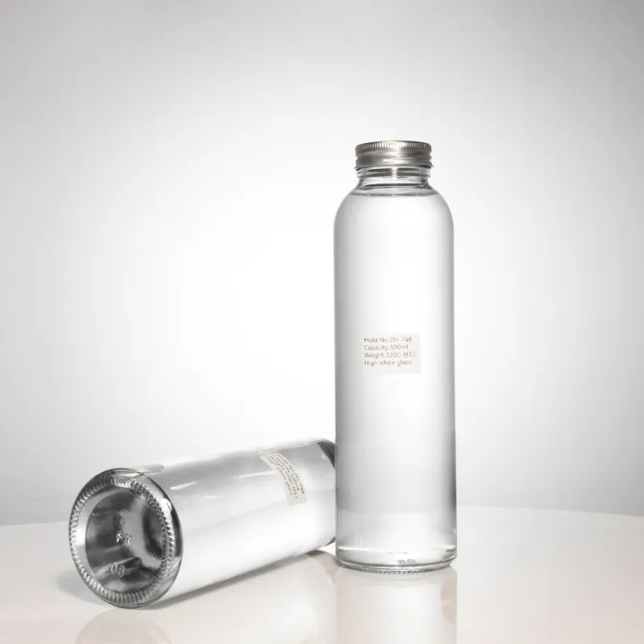 Clear cylindrical beverage bottles with silver aluminum caps