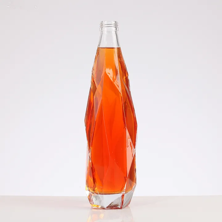 Faceted beverage bottle filled with orange drink