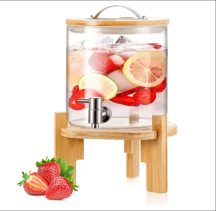 Distributeur de boissons cylindrique rempli de fraises, de citrons, de glaçons et de boisson