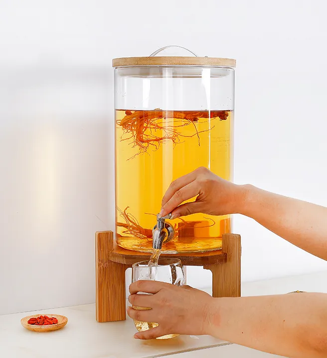 Distributeur de boissons cylindrique muni d'un couvercle en bambou, servant à verser une boisson dans un verre