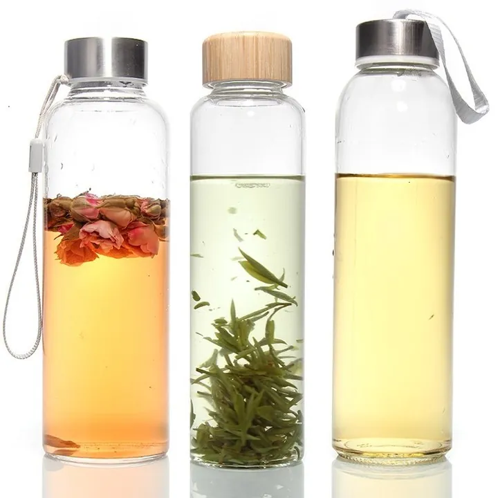 Three glass drinking bottles with tea beverages metal lids and wooden lids