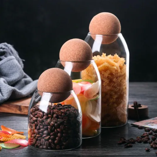 Trois bocaux en verre munis d'un couvercle à bouchon en liège, remplis de bonbons au café et de pâtes
