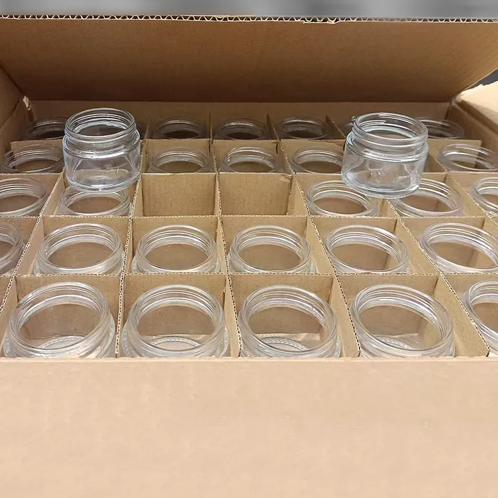 Clear glass cream jars arranged in divided carton packaging