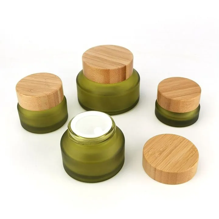 Frosted olive green cream jars with bamboo lids